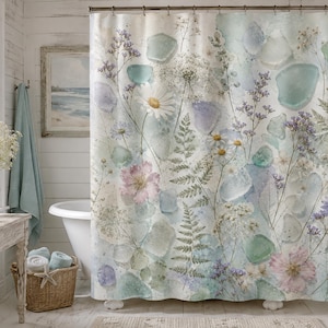 May include: A shower curtain featuring a botanical print of white daisies, pink flowers, purple sprigs, and green ferns interspersed with translucent sea glass shapes in shades of blue, green, and white against a soft, light-colored background.