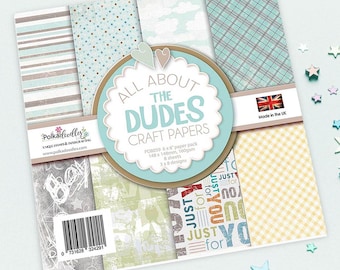 May include: A pack of 8 patterned craft papers with a blue, white, and yellow color scheme. The papers feature a variety of designs, including stripes, polka dots, clouds, and plaid. The pack is labeled "All About The Dudes Craft Papers" and includes the text "Just for You".