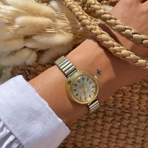 Vintage 1970s Automatic Swiss Made Manual Wind Up Round Rolled Gold Case Ladies Wristwatch With Gold Stretchy Strap, Date Sub Dial By Avia