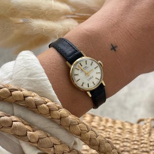 Vintage 1970s Swiss Made Gold Plated Bezel Manual Wind Up Black Leather Strap Ladies Everyday Elegant Dress Wristwatch By Montine