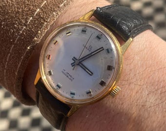 Relógio de pulso vintage Sparewa, década de 1970, bisel banhado a ouro, pulseira preta.