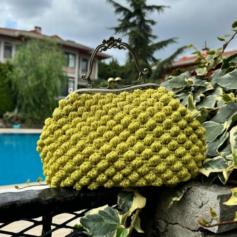 May include: A lime green crocheted clutch purse with a vintage brass clasp and handle.