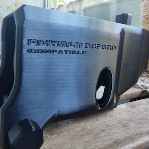 Puede incluir: Pieza de pl&aacute;stico negro impresa en 3D para un taladro DeWalt DCF620. La pieza es compatible con el taladro y tiene una superficie texturizada.