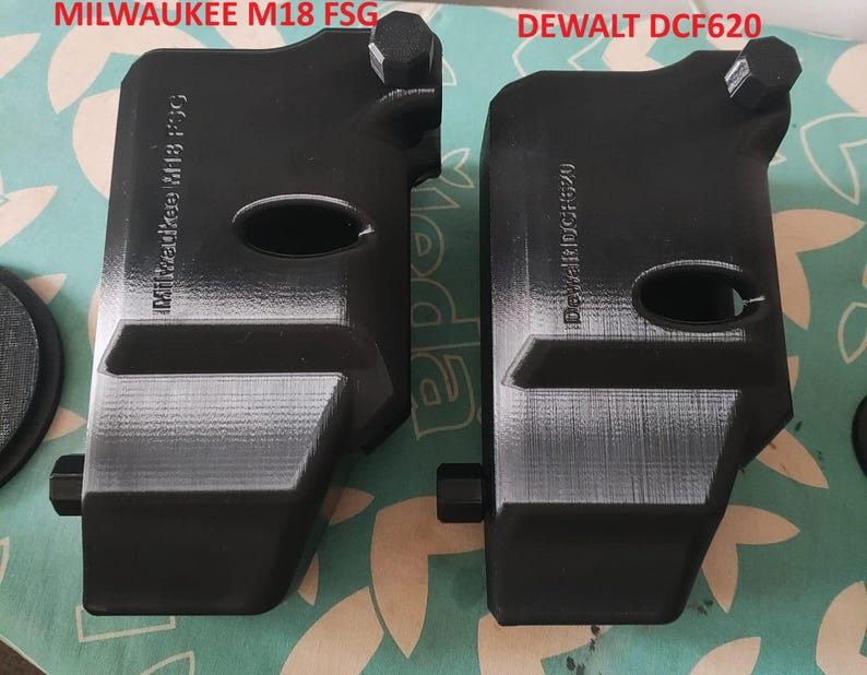 Puede incluir: Primer plano de dos carcasas de bater&iacute;a de herramienta de pl&aacute;stico negro. La carcasa de la izquierda est&aacute; etiquetada como "MILWAUKEE M18 FSG" y la carcasa de la derecha est&aacute; etiquetada como "DEWALT DCF620".