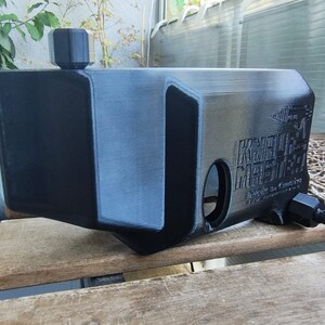 Puede incluir: Un tanque de agua de pl&aacute;stico negro con una tapa negra y una etiqueta que dice "KUSTOM MEETS", "Made in China" y "100% Food Grade".