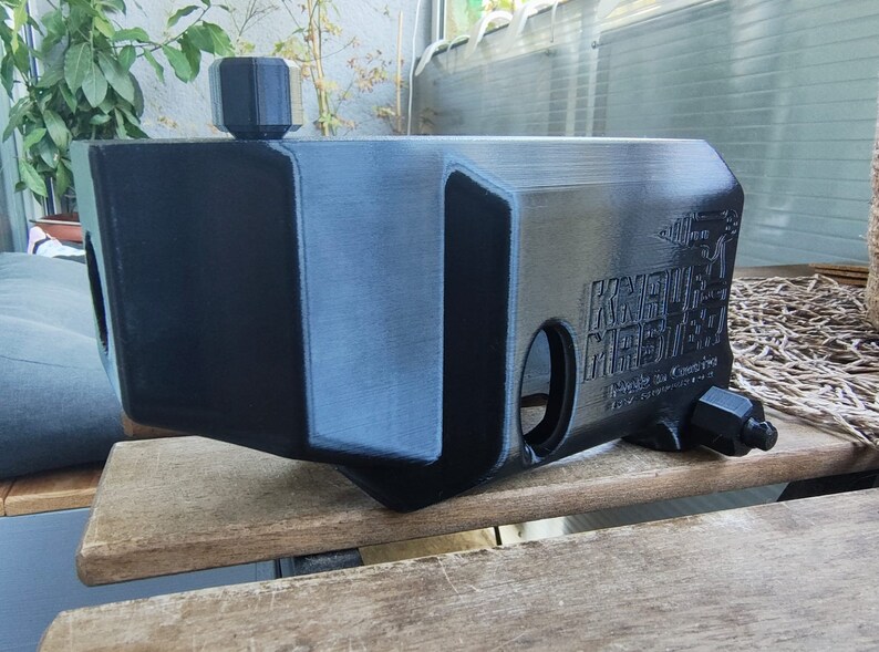 Puede incluir: Un tanque de agua de pl&aacute;stico negro con una tapa negra y una etiqueta que dice "KUSTOM MEETS", "Made in China" y "100% Food Grade".