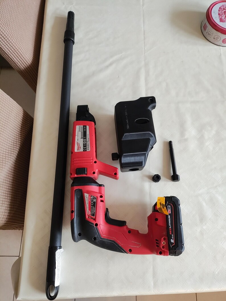 Puede incluir: Un taladro inal&aacute;mbrico rojo y negro con una bater&iacute;a negra y una varilla de extensi&oacute;n negra larga. El taladro tiene un gatillo negro y rojo y un mango negro. La bater&iacute;a tiene el texto "2.0Ah REDLITHIUM" en ella.