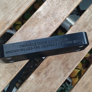 Puede incluir: Conector de varilla triangular de pl&aacute;stico negro con el texto "Triangle Rods Compatible. Shown values are degrees per side (DPS)".