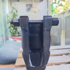 Puede incluir: Una herramienta de pl&aacute;stico negro con forma de U y un pasador de metal. La herramienta est&aacute; dise&ntilde;ada para usarse con una cadena de bicicleta.