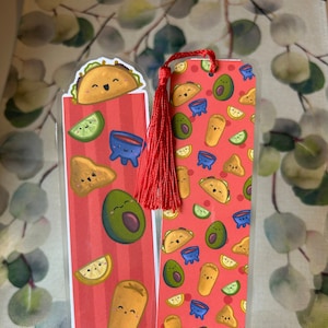 May include: Two red and white patterned bookmarks with a red tassel. One bookmark features a cartoon taco, avocado, lime, and a bowl of salsa. The other bookmark has a repeating pattern of tacos, avocados, limes, and bowls of salsa.