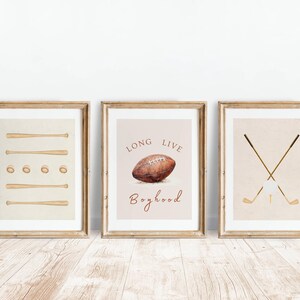 May include: Three framed prints with a sports theme. The first print features a baseball bat and ball design. The second print features a football with the text "Long Live Boyhood". The third print features two crossed golf clubs with a golf ball.