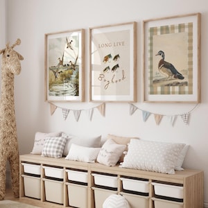 May include: Three framed prints with a nature theme. The left print shows a watercolor illustration of ducks in a pond. The center print has a watercolor illustration of fishing flies and the text "Long Live Boyhood". The right print shows a watercolor illustration of a duck on a plaid background.