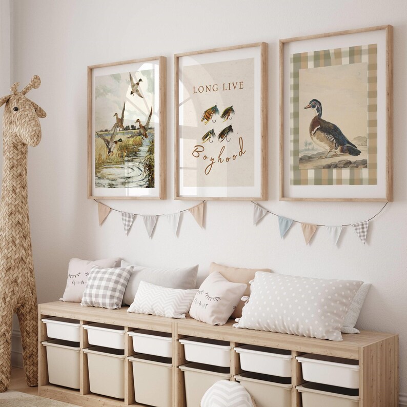 May include: Three framed prints with a nature theme. The left print shows a watercolor illustration of ducks in a pond. The center print has a watercolor illustration of fishing flies and the text "Long Live Boyhood". The right print shows a watercolor illustration of a duck on a plaid background.