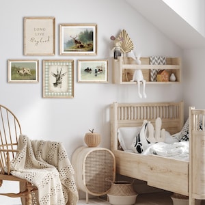 May include: A nursery room with a white wall and a wooden bed with a white and black patterned pillow. There are five framed pictures on the wall, including a deer, ducks, and a sign that says "Long Live Boyhood".