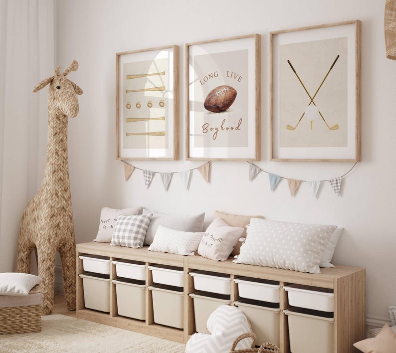 May include: Three framed prints with a sports theme. The first print features a baseball bat and ball, the second print features a football and the text "Long Live Boyhood", and the third print features two golf clubs and a golf ball.