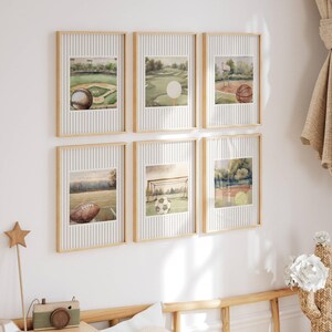 May include: Six framed watercolor prints featuring sports themes. The prints depict a baseball field with a baseball, a golf course with a golf ball, a basketball court with a basketball, a football field with a football, a soccer field with a soccer ball, and a tennis court with tennis balls.