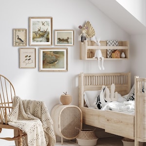 May include: A light wood framed bed with a white and black patterned pillow and a white blanket. There are several framed prints on the wall behind the bed, including one with the text "Long Live Bigfoot".