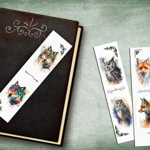 May include: Four watercolor bookmarks featuring a wolf, an owl, and a fox. The bookmarks are white with black decorative borders. The wolf is blue, green, and purple. The owl is brown, gray, and white. The fox is orange, white, and brown.