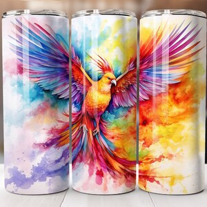 Könnte beinhalten: Drei Edelstahlbecher mit einem farbenfrohen Aquarelldesign eines Vogels mit ausgebreiteten Flügeln. Der Vogel ist gelb, rot und blau mit einem langen Schwanz.