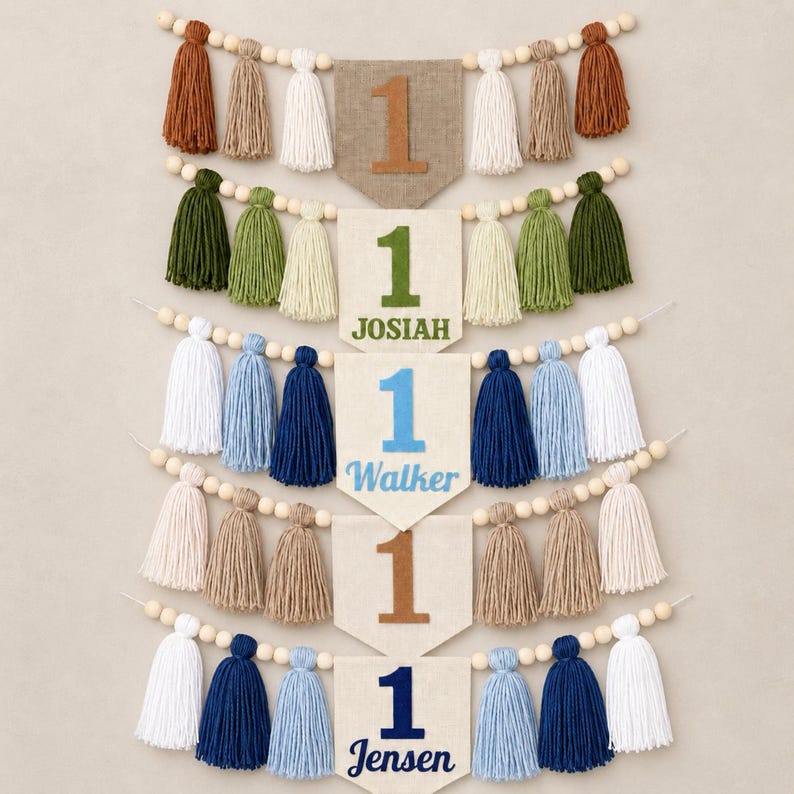 May include: Five pennant banners featuring the number 1, each strung with wooden beads and yarn tassels in various colors. The banners display the names JOSIAH, WALKER, and JENSEN in different colored fonts, while two banners show only the number 1.
