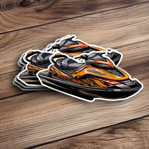 May include: A sticker of a yellow and black jet ski with a white outline. The jet ski has a black seat and a black and white graphic design on the side. The sticker is on a wooden surface.