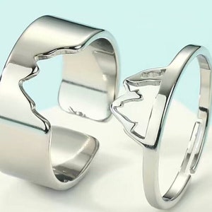 May include: Two silver rings with a mountain range design. The rings are designed to fit together, creating a complete mountain range.