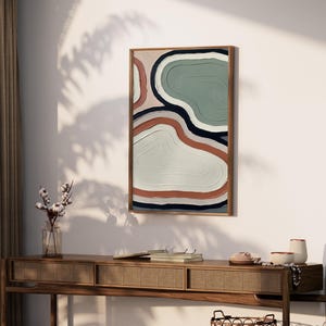 Könnte beinhalten: Ein rechteckiges Wandbild in einem Holzrahmen mit einem abstrakten Design aus geschichteten, organischen Formen in Salbeigrün, Terrakotta-Orange, Creme und Dunkelmarineblau, mit durchgehend sichtbaren, texturierten Pinselstrichen.