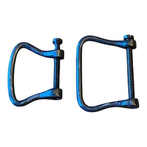 May include: Two antique metal clamps with a dark, aged finish. Each clamp has a curved handle and a threaded screw mechanism for adjusting the opening. The clamps are likely used for woodworking or other crafting projects.