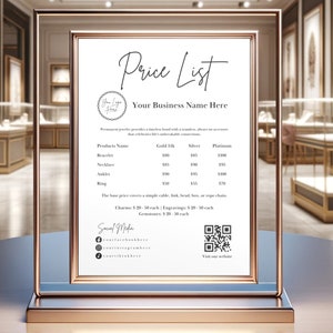 May include: A white price list sign with a gold frame and base. The sign lists prices for jewelry items such as bracelets, necklaces, anklets, and rings in gold, silver, and platinum. The sign also includes a QR code and social media handles.