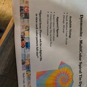 以下が含まれることがあります： Dyenomite MultiColor Spiral Tie-DyeのTシャツデザインが印刷されたシート。Tシャツは黄色、ピンク、青色のスパイラル模様です。サイズはSmallから3XLargeまで。シートには色のバリエーションも表示されています。