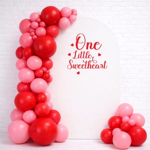 Custom vinyl backdrop decal featuring personalized text in a modern script font. Designed for weddings, birthdays, and special events. Shown applied to a solid wall for a clean, professional look. Ideal for use behind dessert tables, photo booths, or ceremony spaces. Available in various sizes and colors to match your theme. Easy to apply and made for temporary or semi-permanent use. Perfect for adding a personal touch to any celebration.