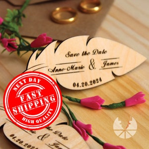 May include: Wooden save the date card shaped like a feather with the text "Save the Date" "Anne-Marie & James" and "04.20.2024".
