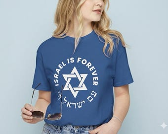 May include: A blue t-shirt with the text "ISRAEL IS FOREVER" encircling a white Star of David. The shirt also has text in Hebrew. The person is holding sunglasses.