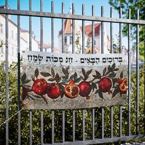 May include: A mosaic banner with a pomegranate design and the Hebrew text "ברוכים הבאים - זה סוכות שמח" which translates to "Welcome - Happy Sukkot".