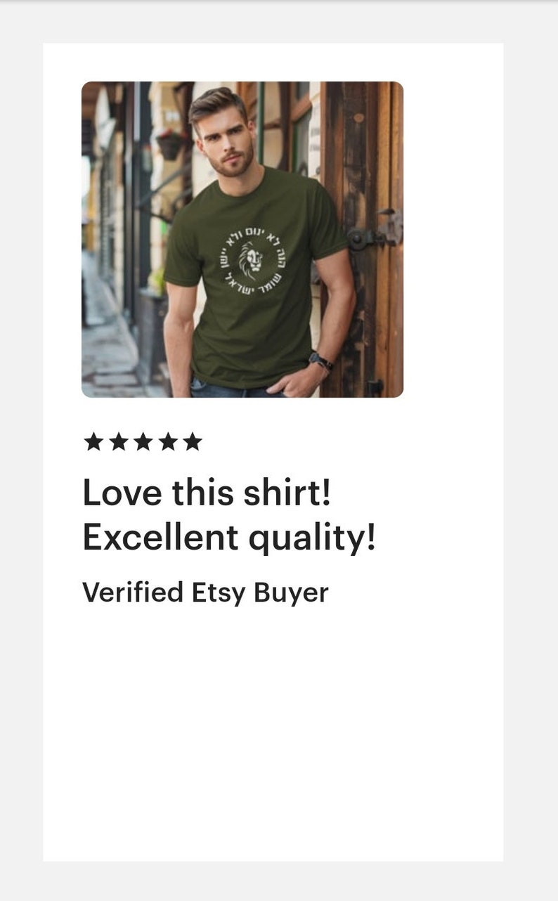 Op de afbeelding: Een olijfgroen t-shirt met korte mouwen en een cirkelvormige afbeelding op de borst. Het ontwerp bevat een centrale illustratie van een leeuwenkop omringd door Hebreeuwse tekst in een ring. Het shirt heeft een ronde hals en een standaard pasvorm.