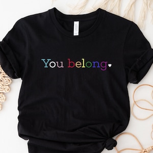 May include: Black t-shirt with the text "You belong" in rainbow colours.