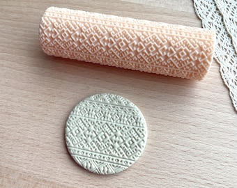 May include: A cylindrical rolling pin with a light peach color and a detailed geometric embossed pattern, accompanied by a circular flat disc of the same light color featuring an identical intricate geometric texture pressed into its surface.