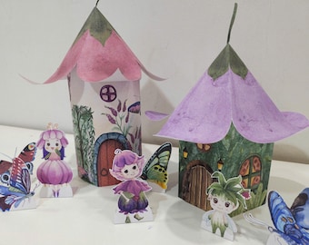 May include: Two miniature fairy houses made of paper with purple and pink roofs. The houses have small doors and windows. There are four fairy figurines with purple and pink dresses and butterfly wings. Two butterflies are also included.
