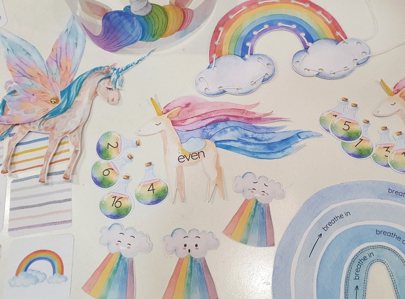 May include: A set of colorful felt craft pieces featuring unicorns, rainbows, clouds, and potion bottles with numbers. The pieces are designed for children's crafts and activities.