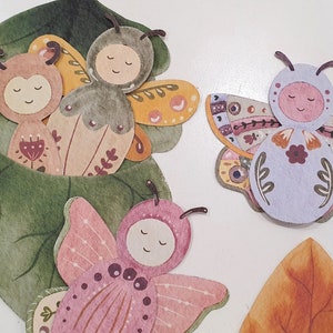 May include: A set of five colorful paper butterflies with intricate designs. The butterflies are decorated with flowers, leaves, and dots. They are perfect for adding a touch of whimsy to any craft project.