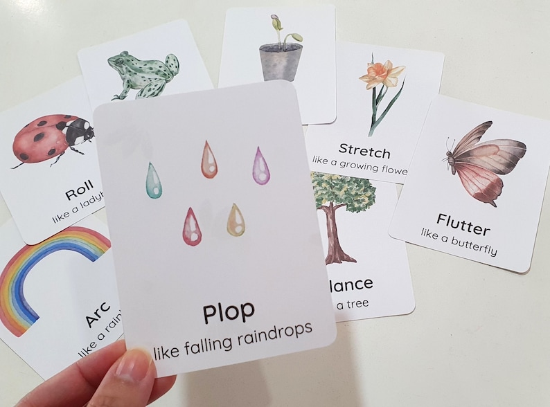 May include: A set of flashcards with colorful illustrations and words describing different actions. The words include "Roll", "Arc", "Plop", "Stretch", "Flutter", and "Balance".