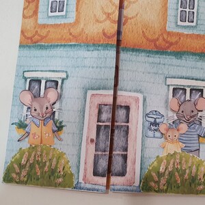 May include: A blue and orange house with two windows and a pink door. Two mice are standing in front of the house. One mouse is wearing a yellow shirt and the other is wearing a blue and white striped shirt. Both mice are holding flowers.