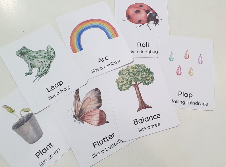 May include: A set of 8 flashcards with watercolor illustrations and text. The cards feature a frog, a butterfly, a rainbow, a ladybug, a tree, a plant, and raindrops. The text on the cards includes words like "leap", "flutter", "arc", "roll", "balance", "plant", and "plop".