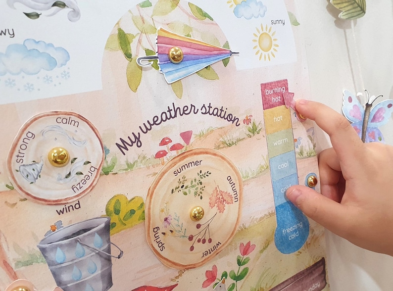 May include: A colorful weather station learning toy with a rainbow umbrella, a thermometer, and four wooden wheels with different seasons: spring, summer, autumn, and winter. The wheels have a gold knob in the center and are decorated with flowers, leaves, and berries.