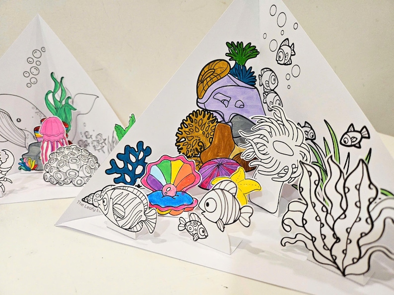 May include: A colorful paper craft depicting an underwater scene with a variety of sea creatures, including a whale, jellyfish, fish, and coral. The craft is made of paper and is designed to be assembled and displayed.