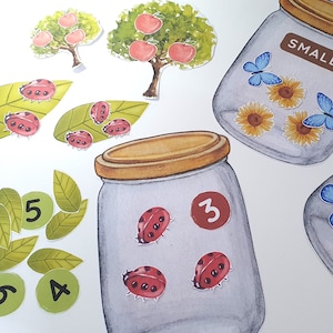 May include: A printable set of ladybug and butterfly counting jar activity for children. The set includes two jars, one labelled "small" and the other with the number "3". There are also leaves with numbers 2, 4, 5, and 6, and leaves with ladybugs.