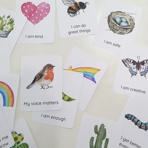 Puede incluir: Conjunto de tarjetas de afirmaci&oacute;n con ilustraciones coloridas y mensajes positivos. Las tarjetas presentan im&aacute;genes de un coraz&oacute;n, una abeille, un nido, un arco&iacute;ris, un petirrojo, una mariposa, un caracol, un cactus, una oruga y una flor. Los mensajes en las tarjetas incluyen "Soy amable", "Puedo hacer grandes cosas", "Estoy seguro", "Mi voz importa", "Soy suficiente", "Soy creativo", "Me pongo mejor cada d&iacute;a", y "Importo en este mundo".
