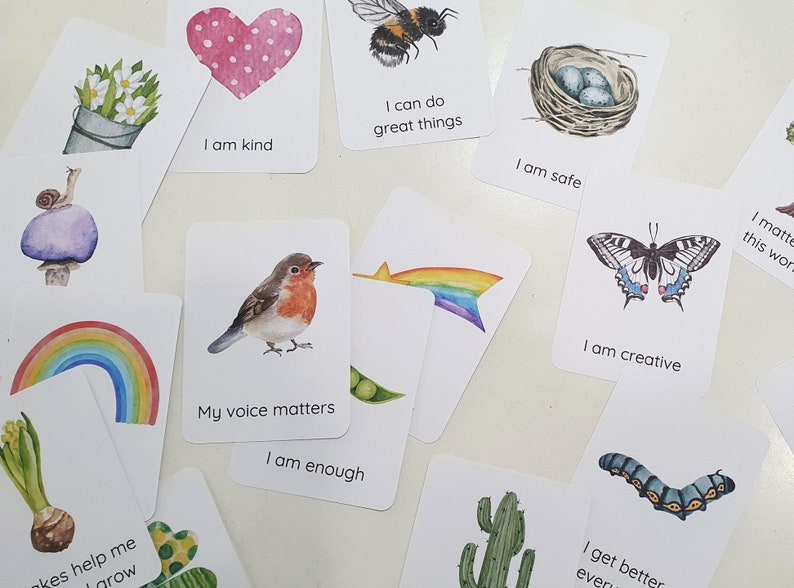 Puede incluir: Conjunto de tarjetas de afirmaci&oacute;n con ilustraciones coloridas y mensajes positivos. Las tarjetas presentan im&aacute;genes de un coraz&oacute;n, una abeille, un nido, un arco&iacute;ris, un petirrojo, una mariposa, un caracol, un cactus, una oruga y una flor. Los mensajes en las tarjetas incluyen "Soy amable", "Puedo hacer grandes cosas", "Estoy seguro", "Mi voz importa", "Soy suficiente", "Soy creativo", "Me pongo mejor cada d&iacute;a", y "Importo en este mundo".