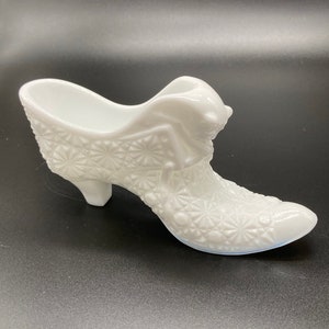Könnte beinhalten: Weiße Milchglas-Schuhform-Schmuckschale mit einem erhabenen Design.