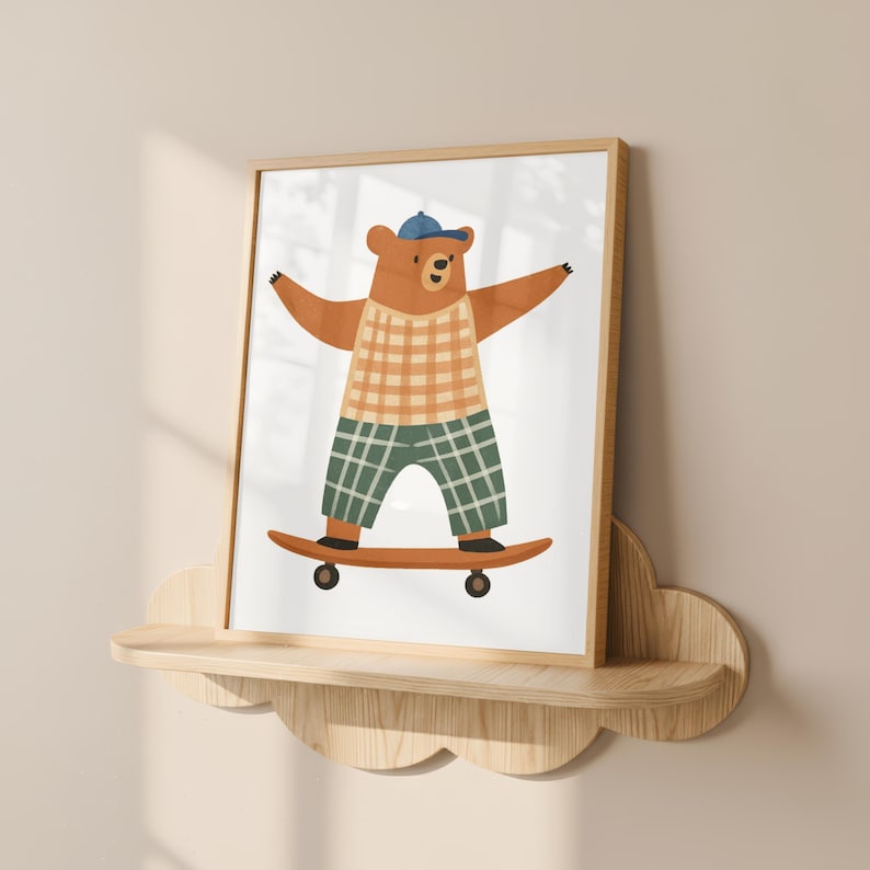 K&ouml;nnte beinhalten: Gerahmter Druck mit einem braunen B&auml;ren auf einem Skateboard. Der B&auml;r tr&auml;gt eine blaue Kappe, ein kariertes Hemd und eine gr&uuml;ne karierte Hose. Das Skateboard ist braun. Das Kunstwerk befindet sich auf einem Holzregal.